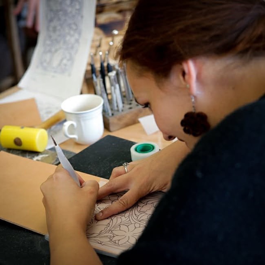Alice Mouchetant au travail dans son atelier, gravant le cuir